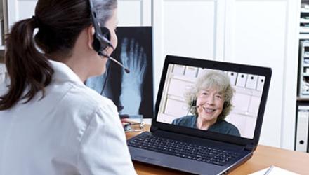 A physio takes part in a video call with a woman